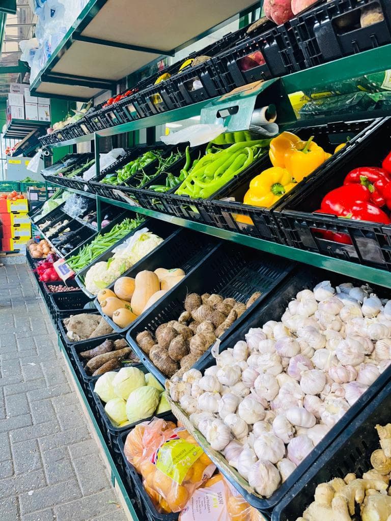 Outdoor fresh produce display with garlic, root vegetables and squash