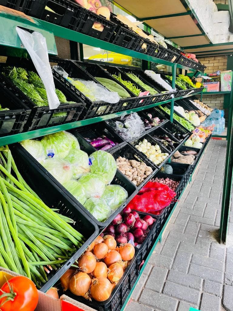 Fresh vegetables and greens displayed outside the store